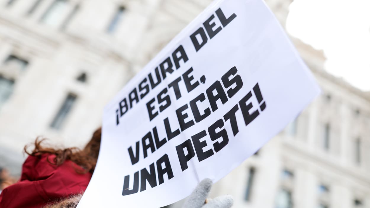 Participante con un cartel que dice "¡Basura del este, Vallecas una peste!" en una manifestación de las Asociaciones vecinales. EP.