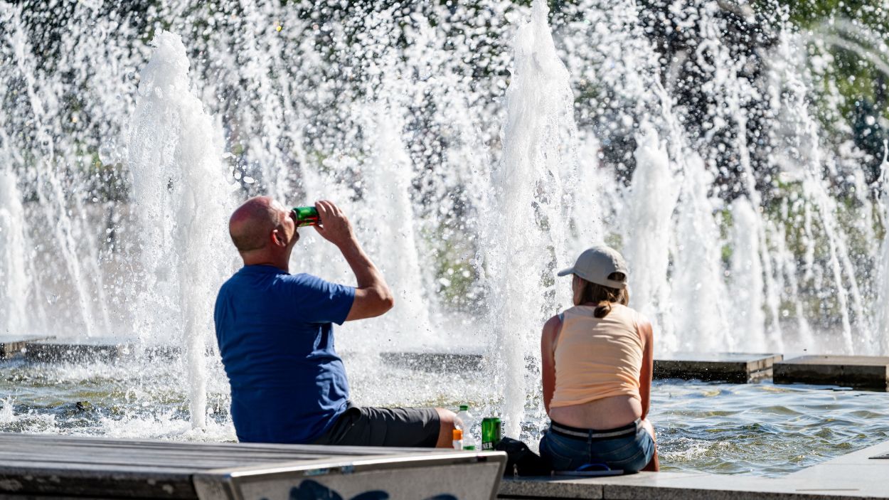 Dos personas refrescándose ante las altas temperaturas de principios de julio 2025. EP.