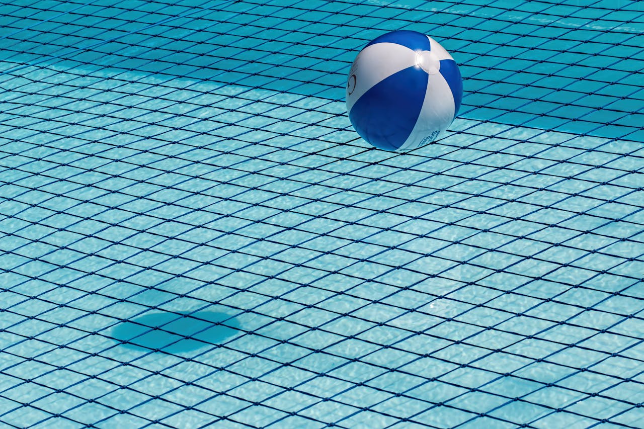 Piscina con una red de protección y una pelota sobre ella