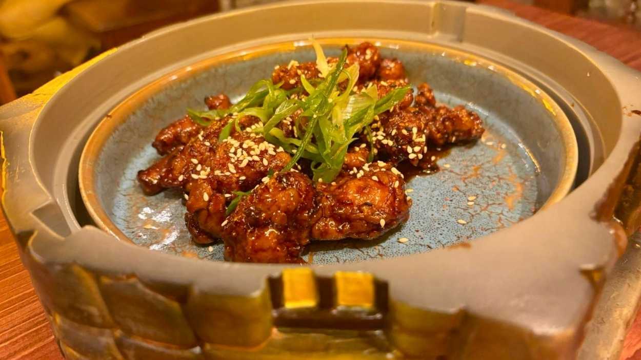 Pollo Caramelizado del Este Perdido. Un plato que mezcla dulzor y acidez con precisión alquímica, servido en una vasija inspirada en el Bosque Prohibido.