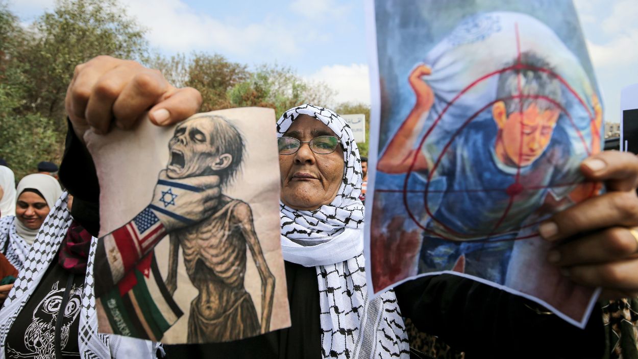 Una refugiada palestina protestando en Beirut muestra imágenes que representan el sufrimiento de los palestinos en la Franja de Gaza. EP