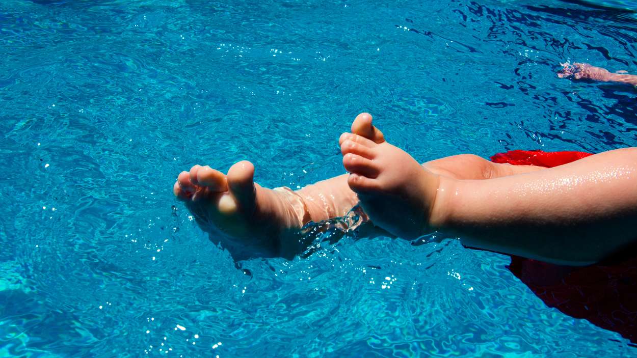 Los pies de un bebé en una piscina.
