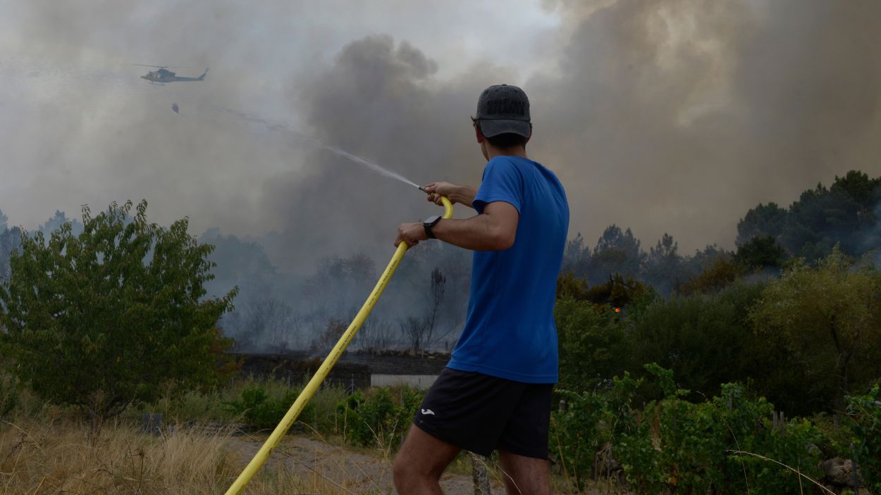 Una persona colabora en la extinción del incendio, a 12 de agosto de 2025, en Seixalbo, Ourense. EP.