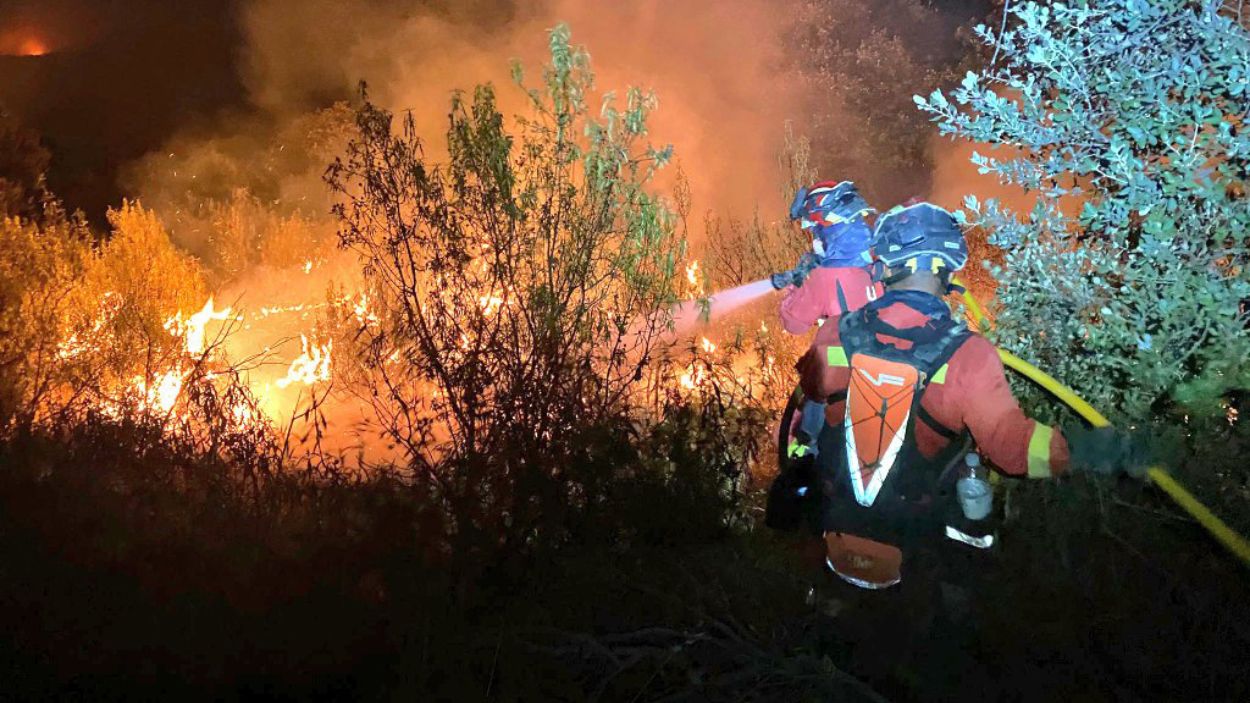 Dos agentes de la Unidad Militar de Emergencias (UME) trabajan en las labores de extinción del incendio en Tres Cantos. EP.
