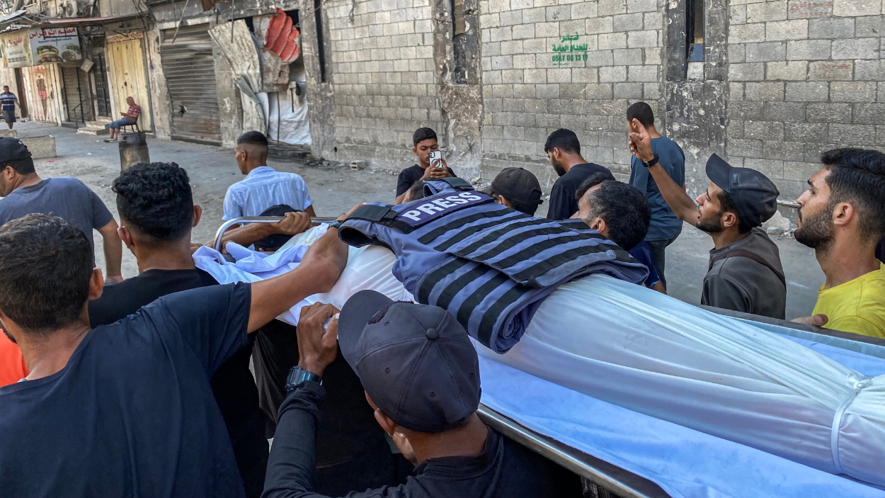 Palestinos llevan los cadáveres de víctimas de ataques aéreos, incluyendo a un periodista. EP