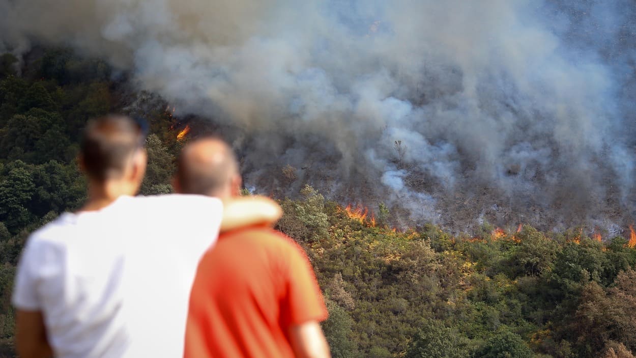 Varias personas observan el incendio en la sierra de O Courel, en Quiroga, Lugo. EP.