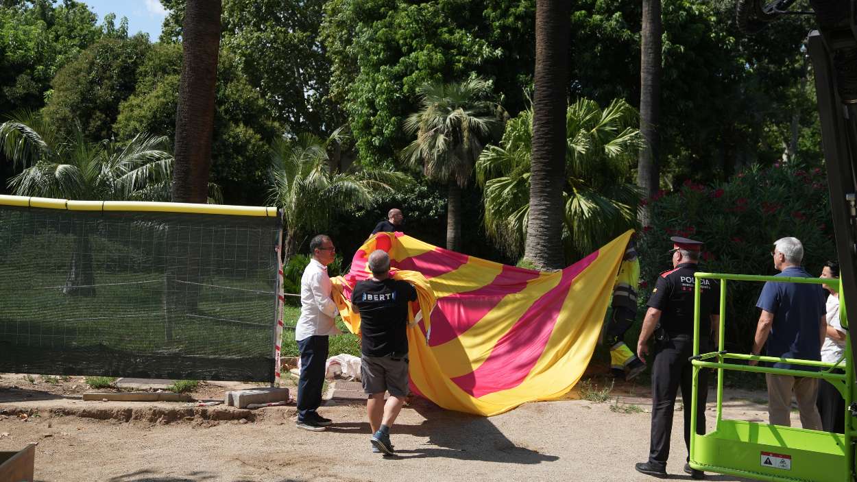 Varias personas manipulan la bandera de la Diada Nacional de Catalunya del 11 de septiembre, a 29 de julio de 2025, en Barcelona, Cataluña (España). 
