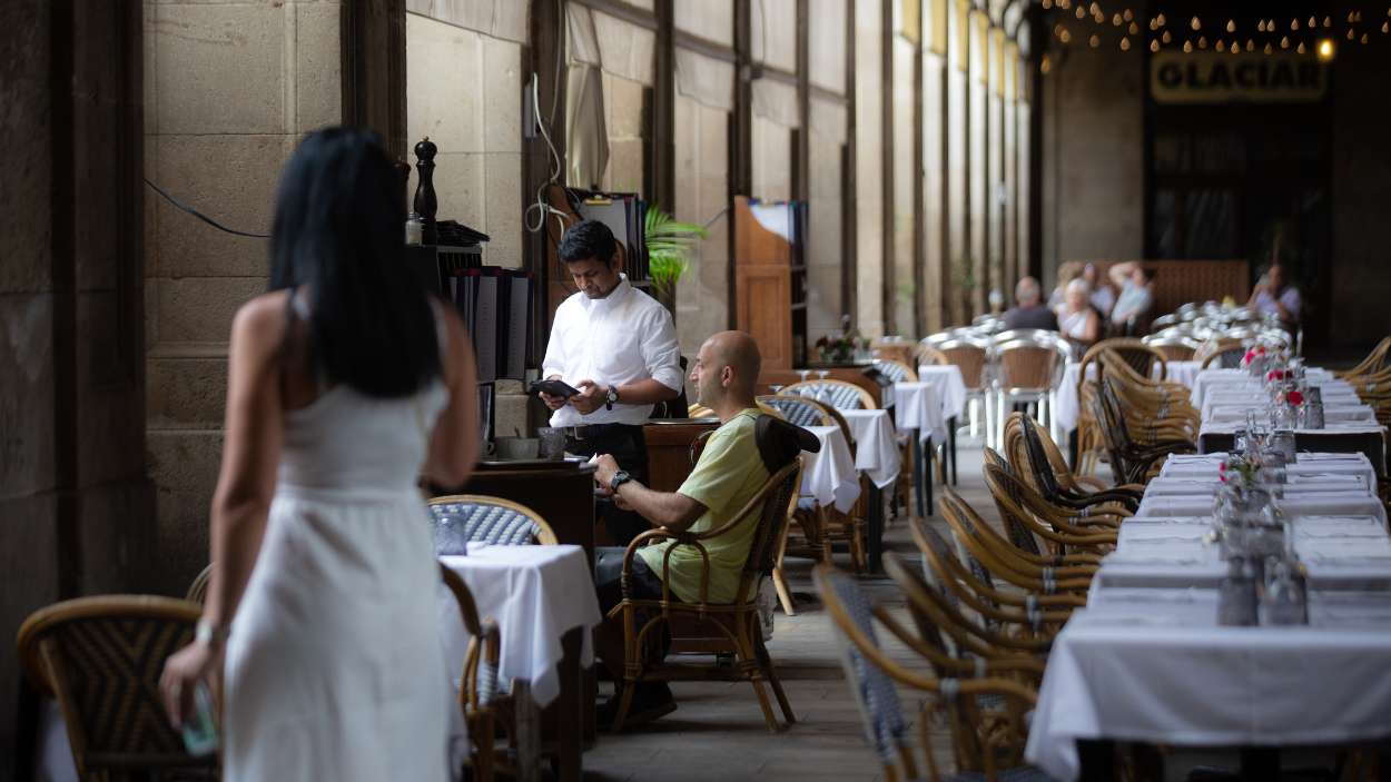Un camarero atiende a una mesa en la plaza Real de Barcelona. EP