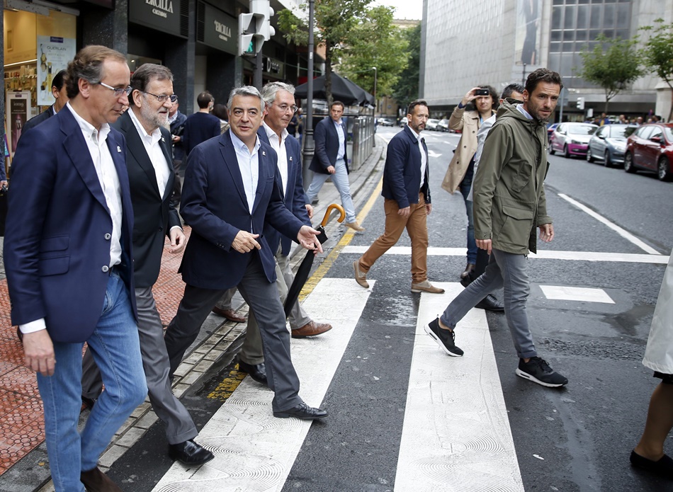 Rajoy cruza, este sábado, por una calle de Bilbao acompañado de Alfonso Alonso y otros dirigentes del PP vasco.