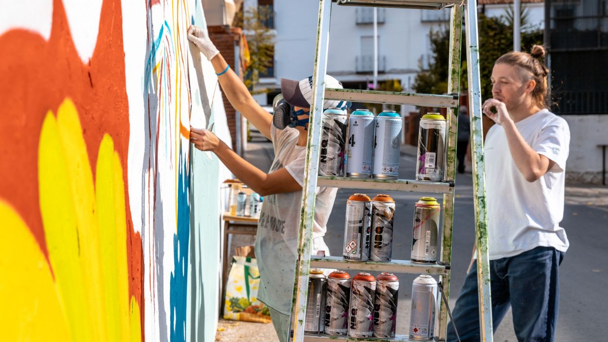 La artista Ana Corazón pinta un mural en la localidad de Valdepeñas de Jaén