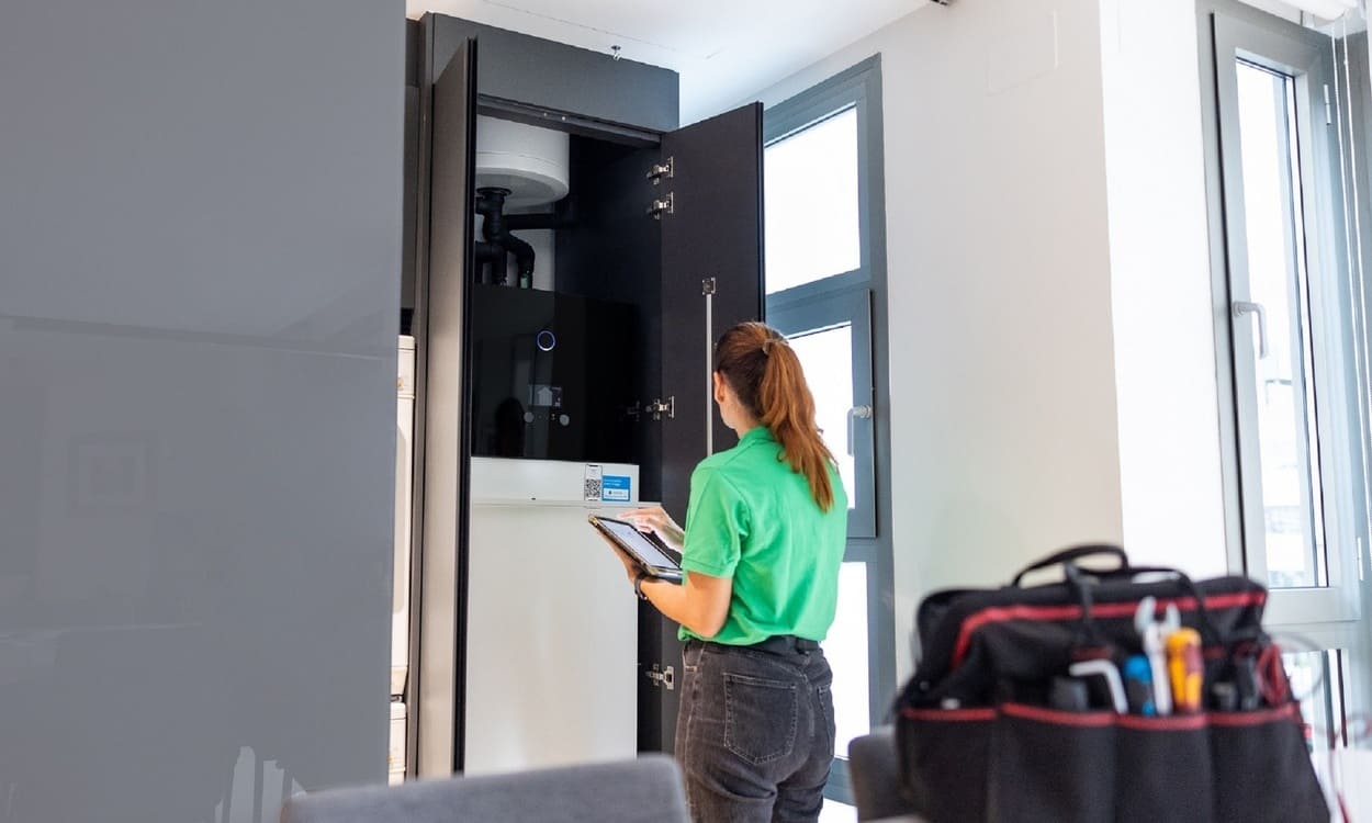 Técnico de Iberdrola ante la unidad interior de aerotermia en una vivienda. IBERDROLA