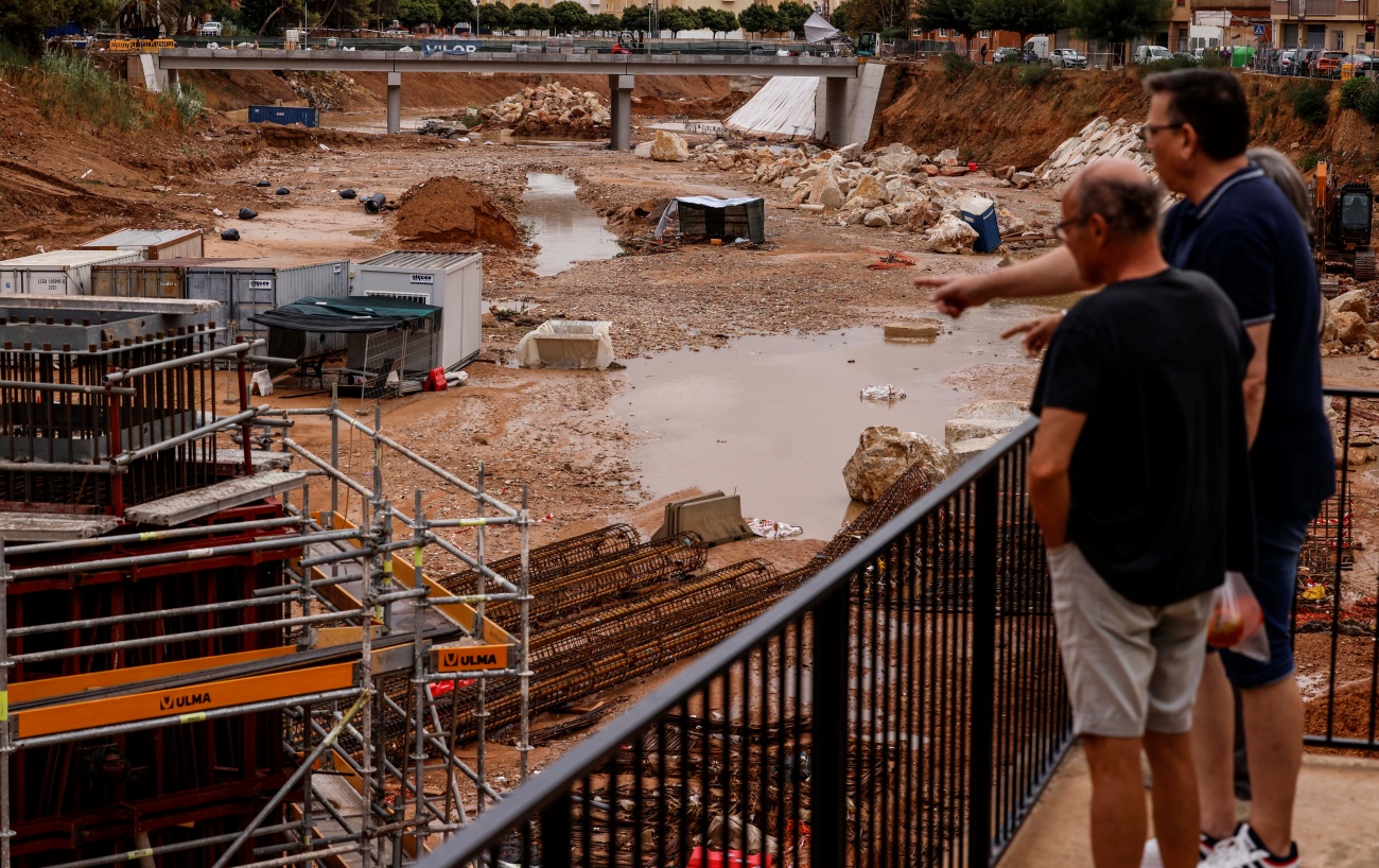 Dos hombres observan el barranco del Poyo tras las lluvias. (Foto: EP)
