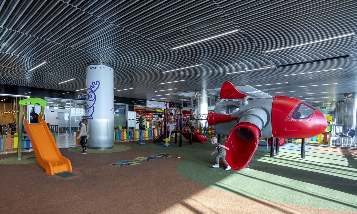 Área de juegos infantiles en el Aeropuerto de Gran Canaria donde los más pequeños pueden entretenerse y liberar energía en un entorno seguro antes del vuelo. Aena