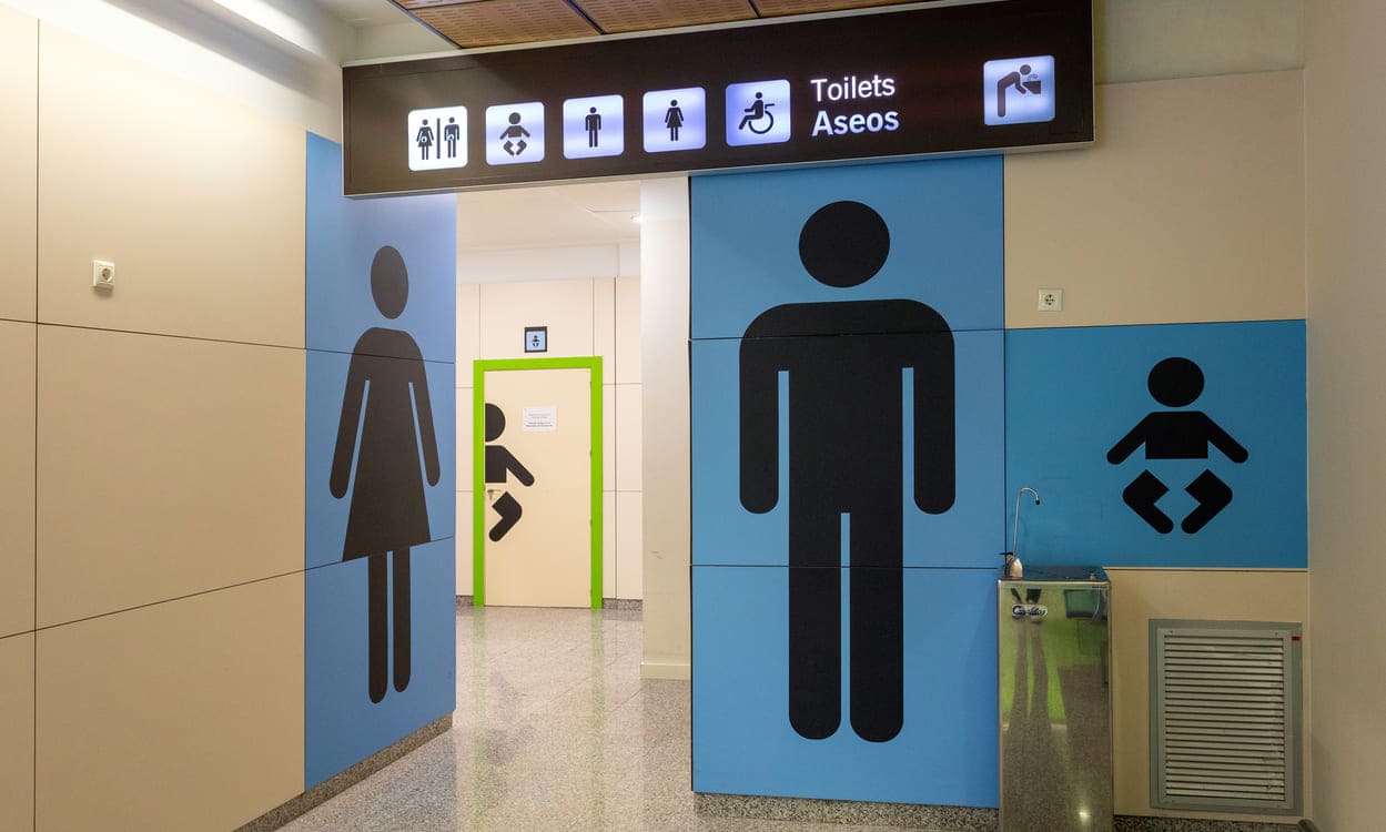 Aseos accesibles e inclusivos en el Aeropuerto Seve Ballesteros-Santander, con señalización clara y zonas adaptadas para personas con diferentes necesidades de movilidad y cuidado. Aena