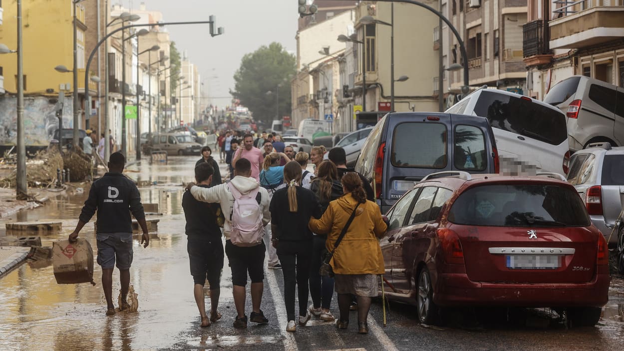 Varias personas junto a coches destrozados tras el paso de la DANA por el barrio de La Torre de Valencia en 2024 (Foto: EP)