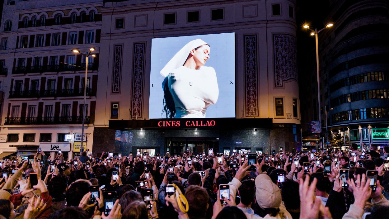 Decenas de personas observan la portada del nuevo álbum de Rosalía, 'Lux', en la plaza de Callao, a 20 de octubre de 2025, en Madrid. EP.