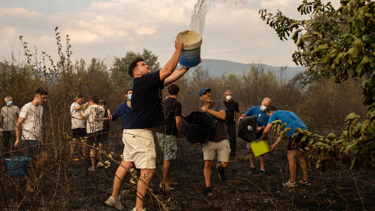 Vecinos de la localidad ayudan en las tareas para la extinción del incendio. EP.