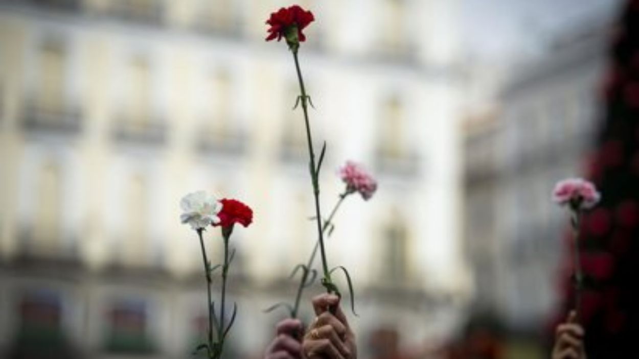 Manifestantes portando flores en homenaje a las víctmas. EP.