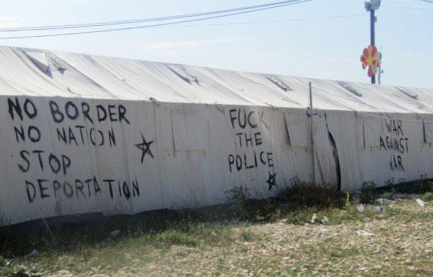 Eslóganes contra la guerra y las deportaciones pintados en una tienda en el campo de refugiados.