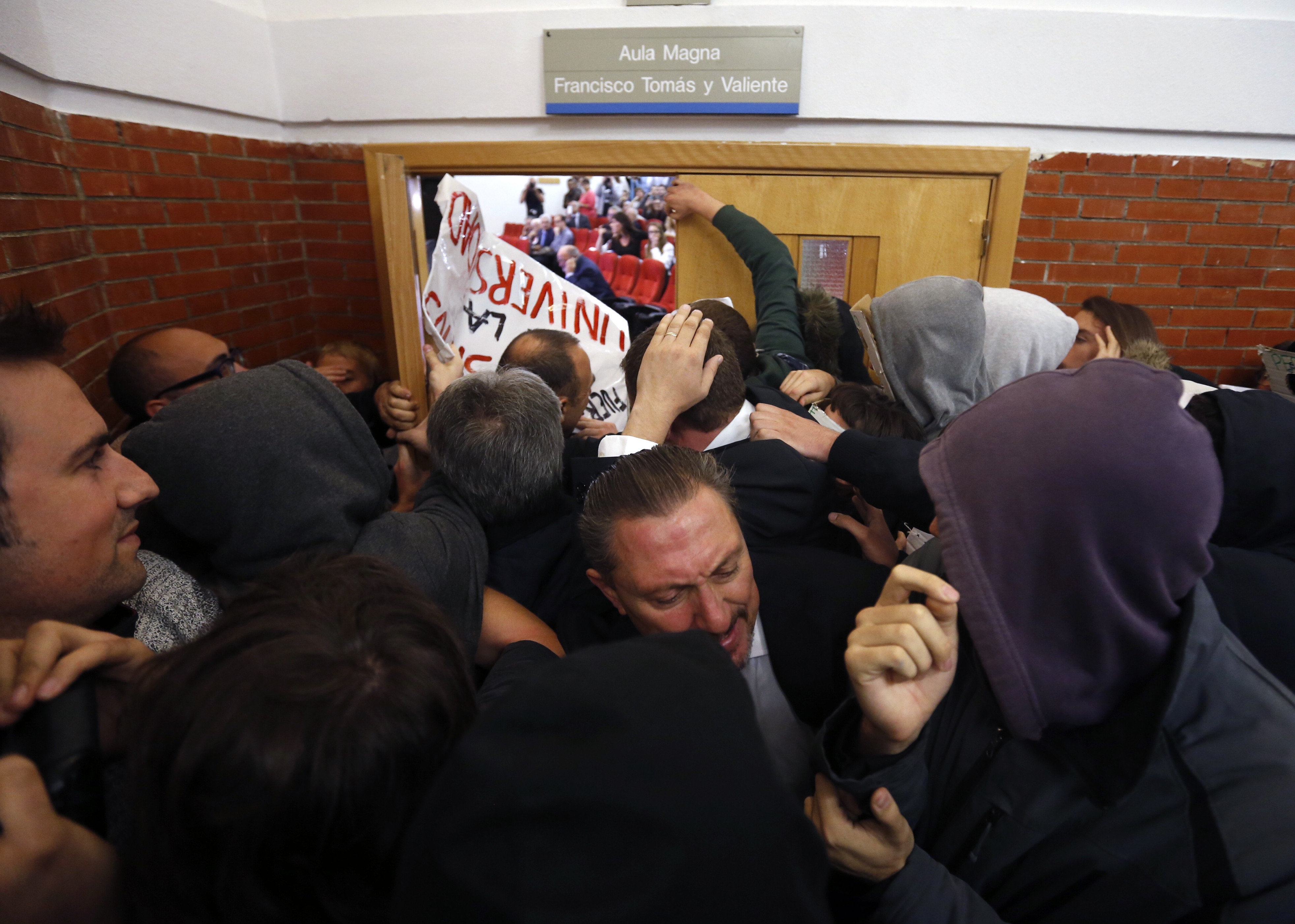 Unos 200 jóvenes taponan la puerta de la facultad de derecho de la Universidad Autónoma de Madrid para impedir la entrada al expresidente del Gobierno Felipe González. 