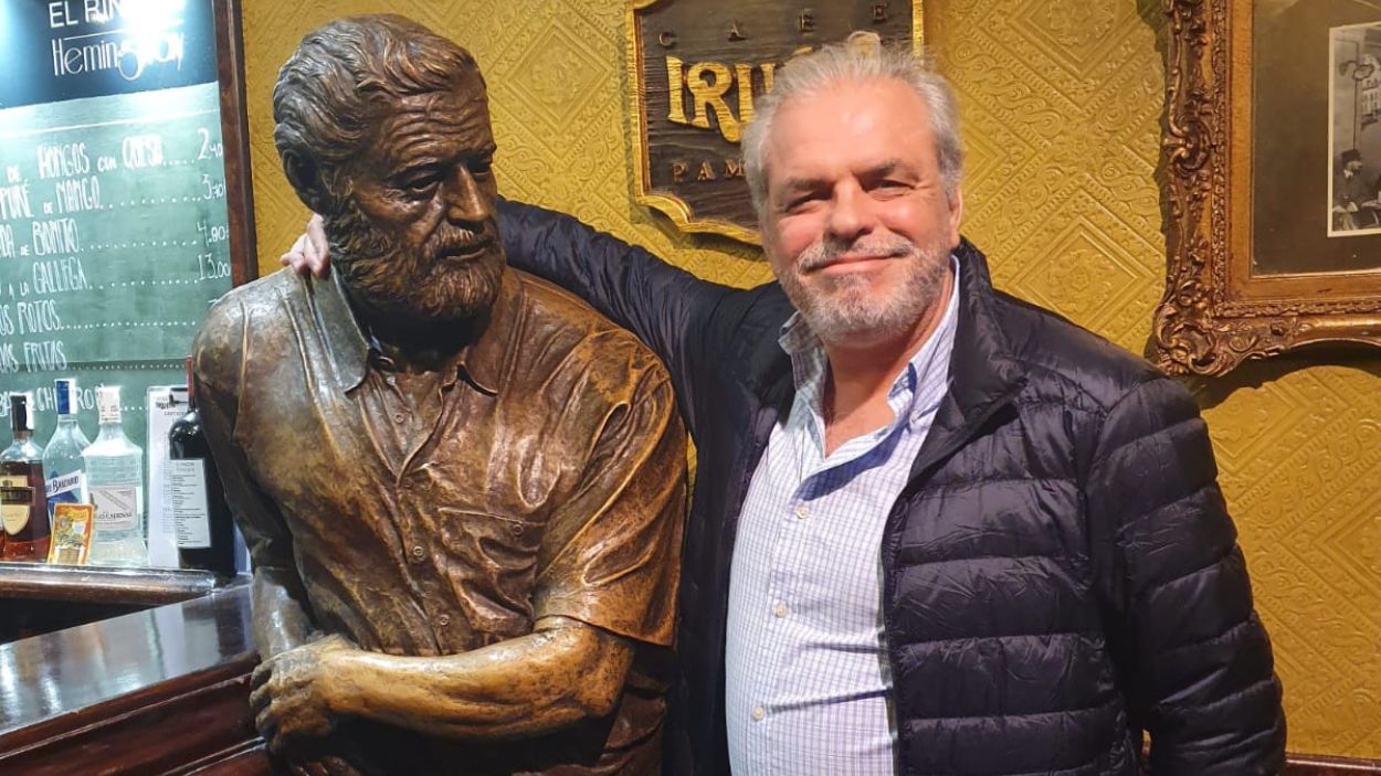 El escritor José Vila del Castillo en 'El rincón del Iruña', en Pamplona, junto a la estatua de Hemingway, hecha en bronce patinado por el escultor José Javier Doncel