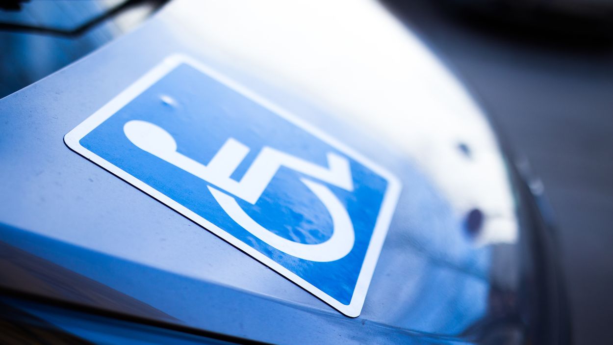 Imagen de un cartel de discapacidad en un vehículo. Canva.