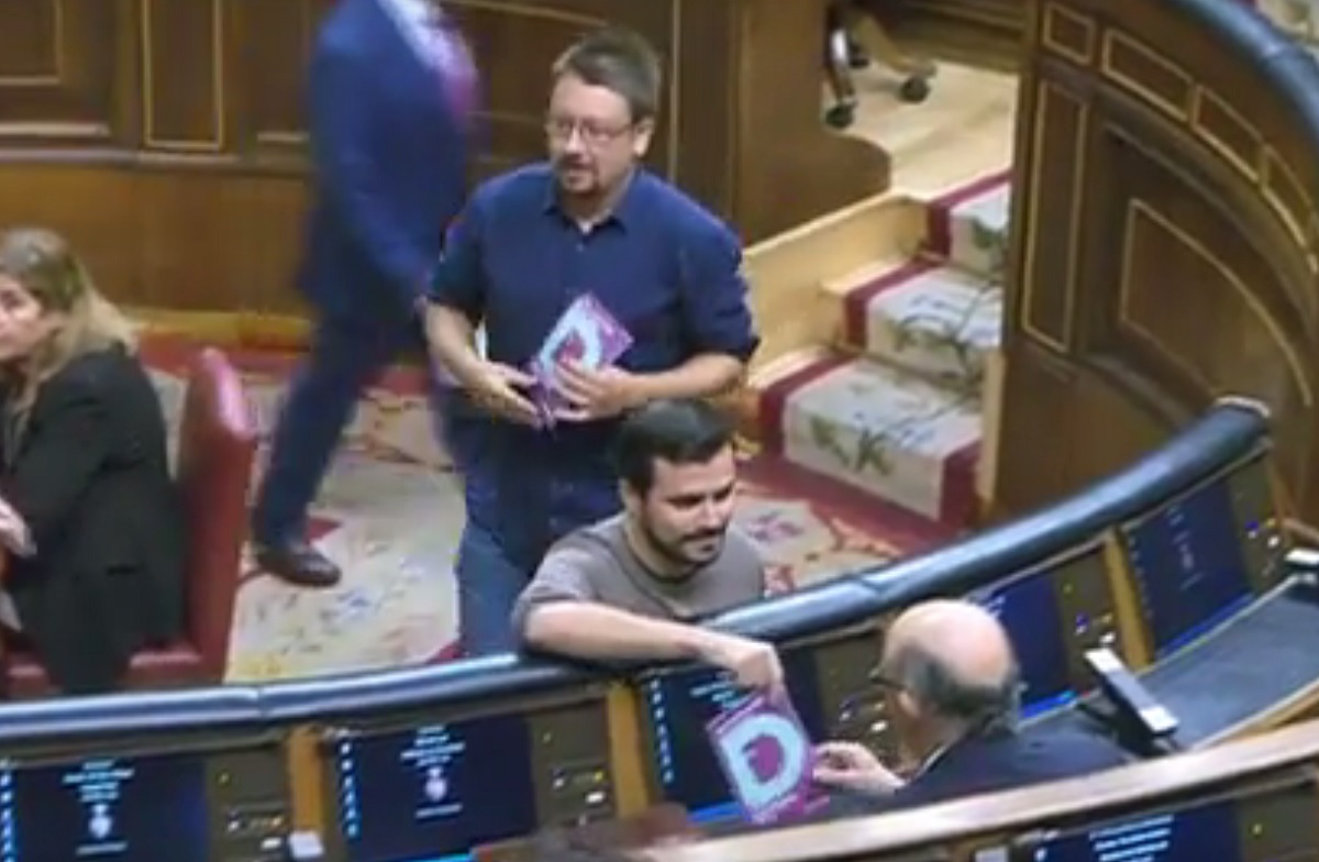 Alberto Garzón y Xavier Doménech entregando los carteles a la bancada del PP