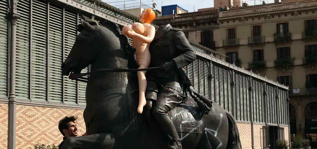 Un artista coloca una muñeca hinchable como protesta en la estatua ecuestre del general Franco frente al edifico del Born de Barcelona. 