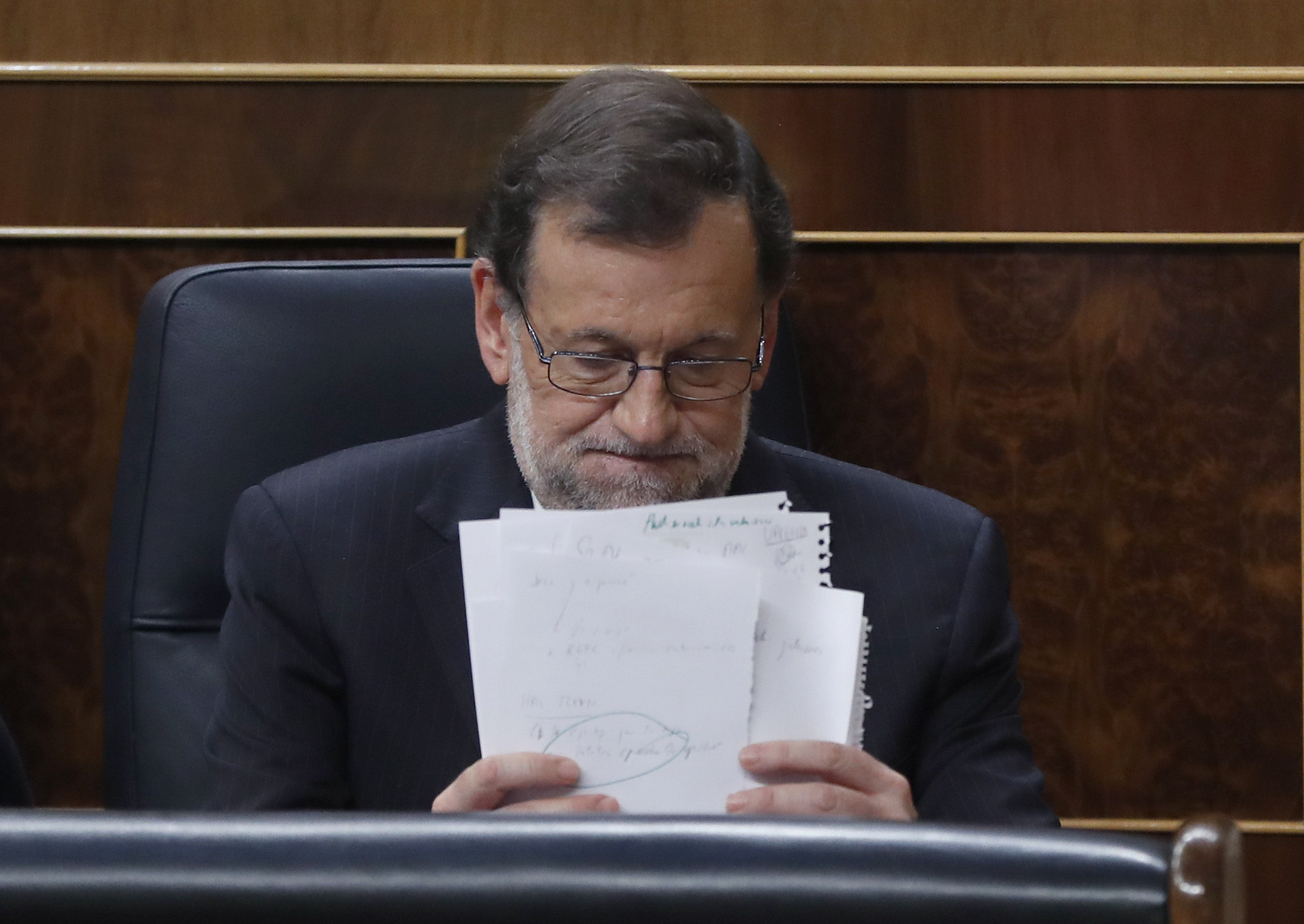 El presidente del Gobierno en funciones y candidato del PP, Mariano Rajoy, coloca unos papeles durante la sesión de la tarde de la segunda jornada del debate de investidura, hoy en el Congreso de los Diputados.