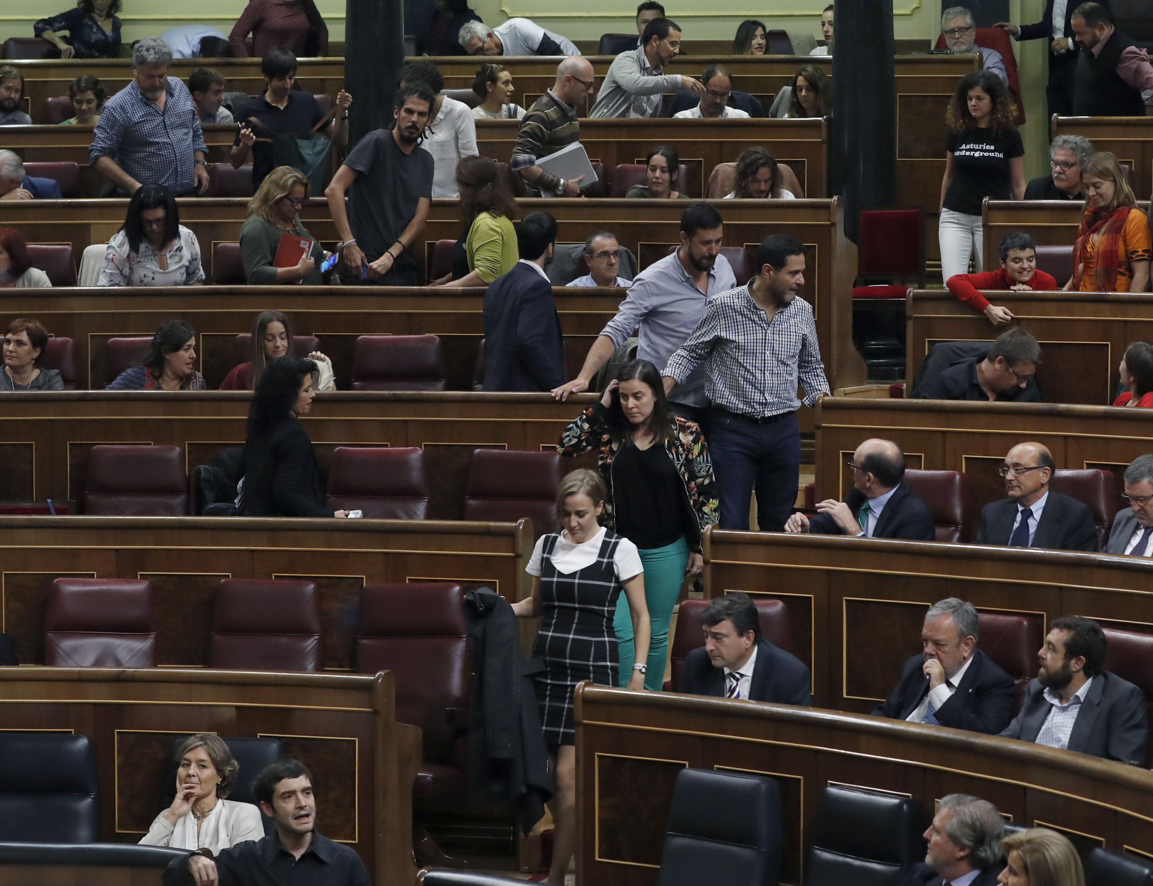 Los diputados de Unidos Podemos abandonan el hemiciclo en protesta por unas palabras del portavoz del PP, Rafael Hernando.