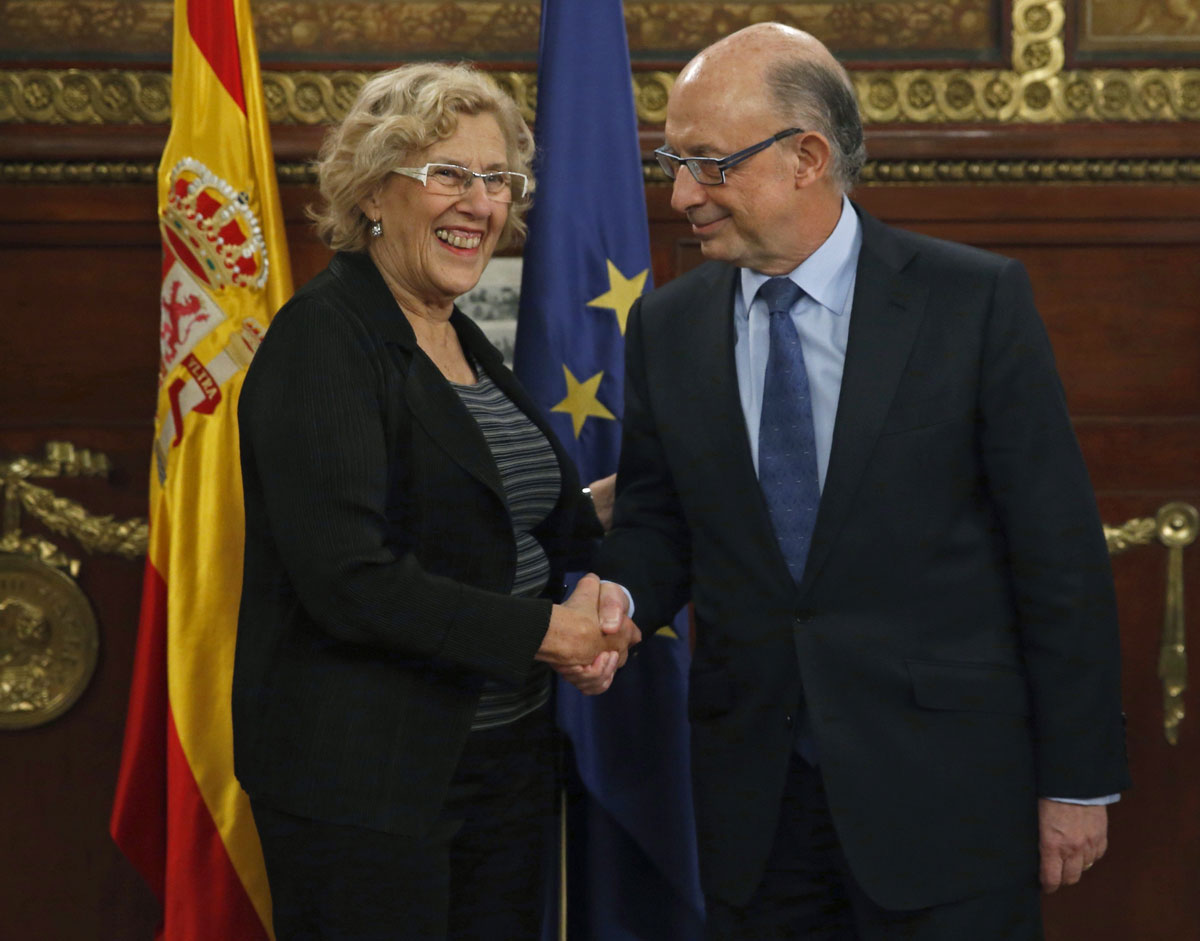 La alcaldesa de Madrid, Manuela Carmena (i), saluda al ministro de Hacienda y Función Pública, Cristóbal Montoro (d)