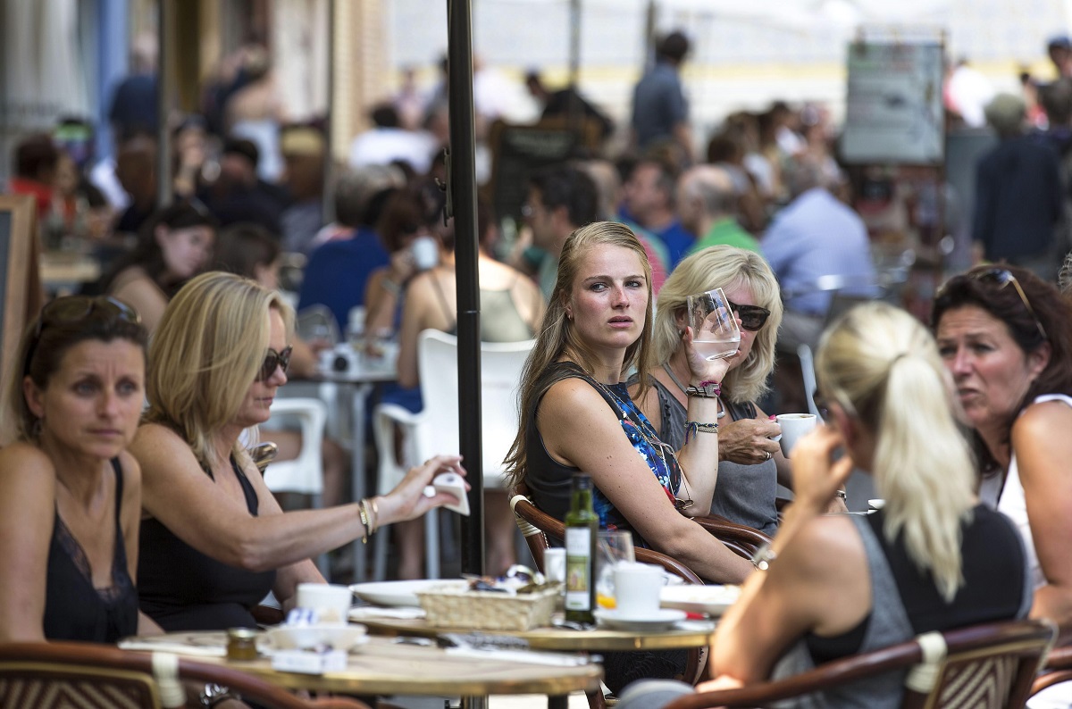 Varios turistas se refrescan en una terraza junto a La Lonja de Valencia