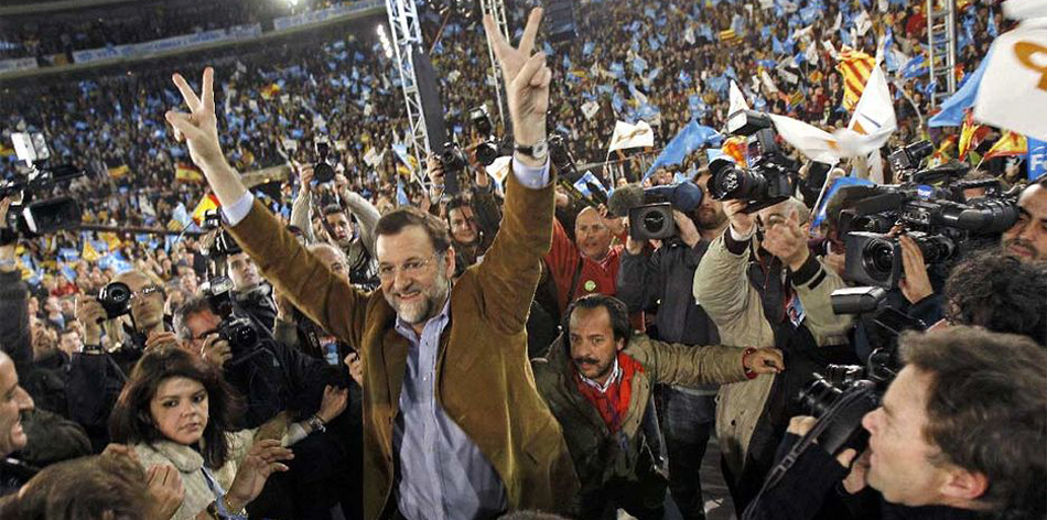 Mariano Rajoy y Álvaro Pérez (agachado, detrás) en un mitin en la Plaza de Toros de Valencia, en 2007