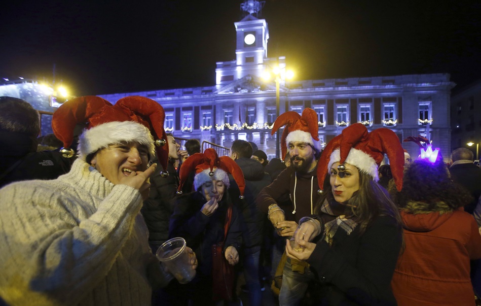 Personas comiendo uvas en la Puerta de Sol de Madrid. 