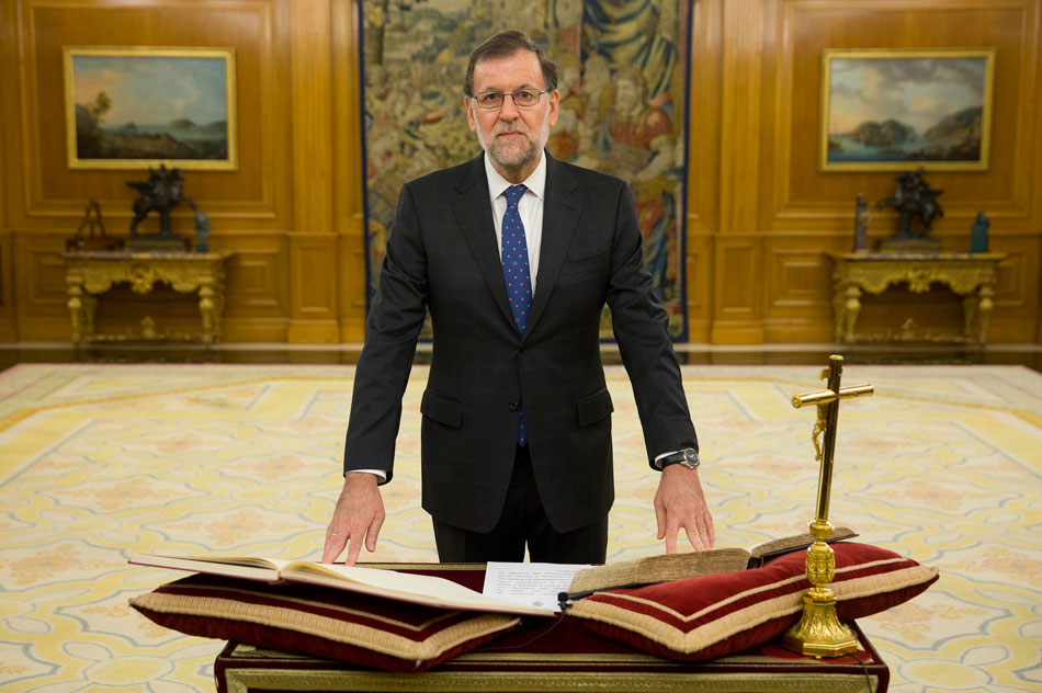 Mariano Rajoy jura su cargo como presidente del Gobierno con una mano en la Biblia y otra en la Constitución y frente a un crucifijo.