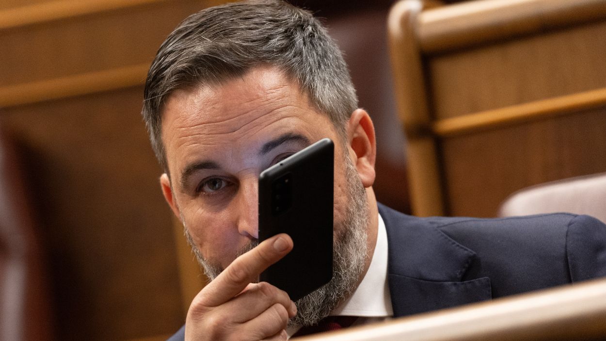 El líder de VOX, Santiago Abascal, con el teléfono móvil durante una sesión plenaria, en el Congreso de los Diputados. EP/Archivo.
