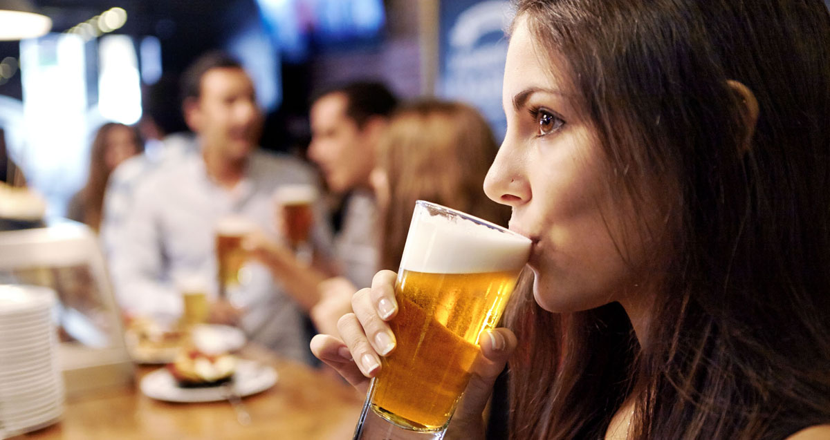 Una chica disfruta de una caña de cerveza. Eliminar