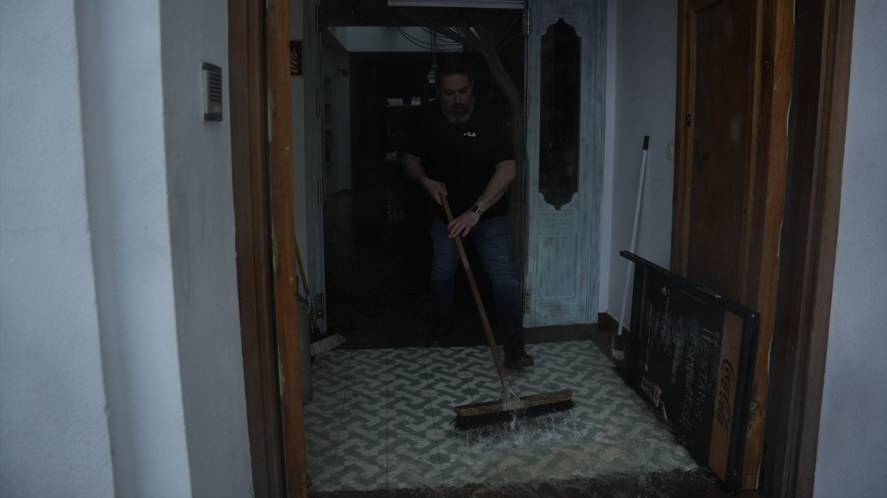 Vecino de Grazalema (Cádiz) achicando agua de su casa / EP