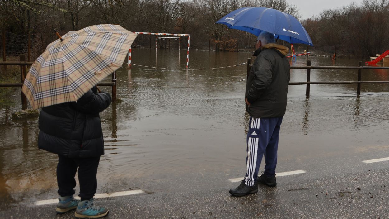 Dos personas observan la crecida del río Duero a su paso por Vilviestre de los Nabos, en Soria. EP.