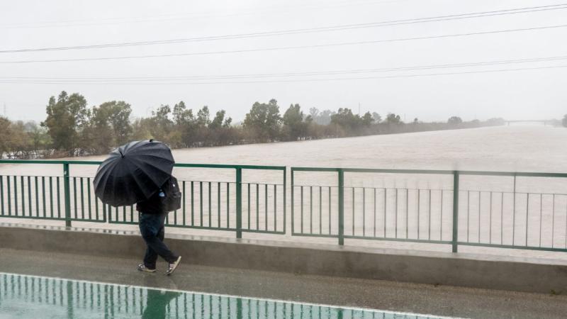 Una persona cruza por el Puente de la Señorita cortado al tráfico por el desbordamiento parcial del río Guadalquivir en Sevilla. EP.