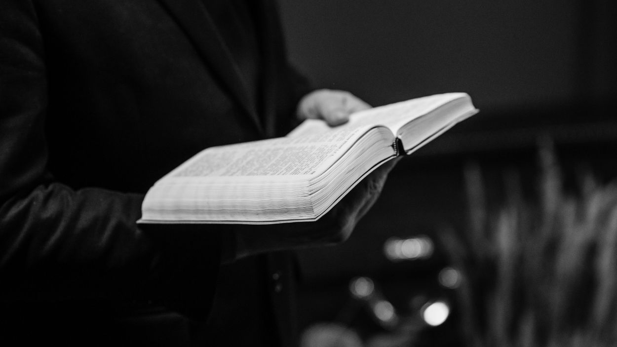 Hombre sujetando una biblia. Pexels