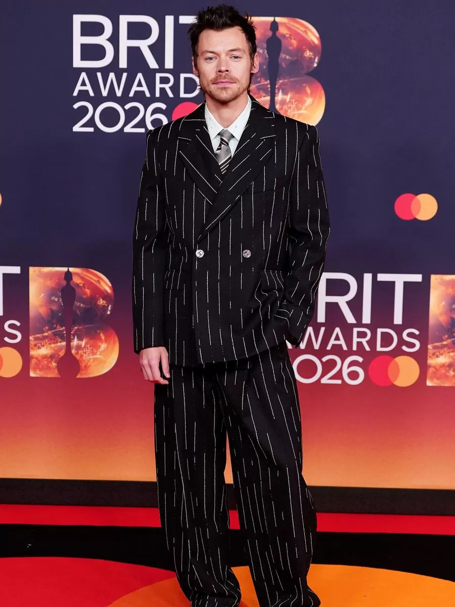 Harry Styles Aparece con un conjunto de dos piezas de sastrería impecable, combinado con polainas tradicionales, reforzando su constante reinterpretación del menswear clásico desde una mirada pop contemporánea.