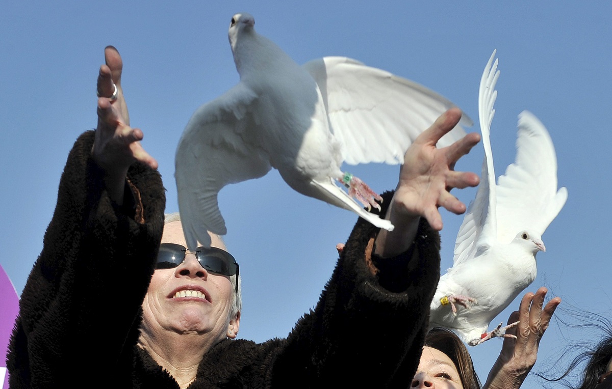La cantante británica Annie Lennox suelta una paloma blanca desde el puente Millennium mientras participa en una marcha convocada con motivo del Día internacional de la Mujer 