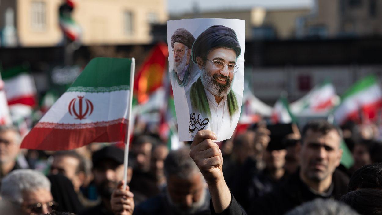 Un hombre sujeta un cartel con la imagen del nuevo líder supremo de Irán, Mojtaba Jamenei, junto a su padre, Alí Jamenei. EP.