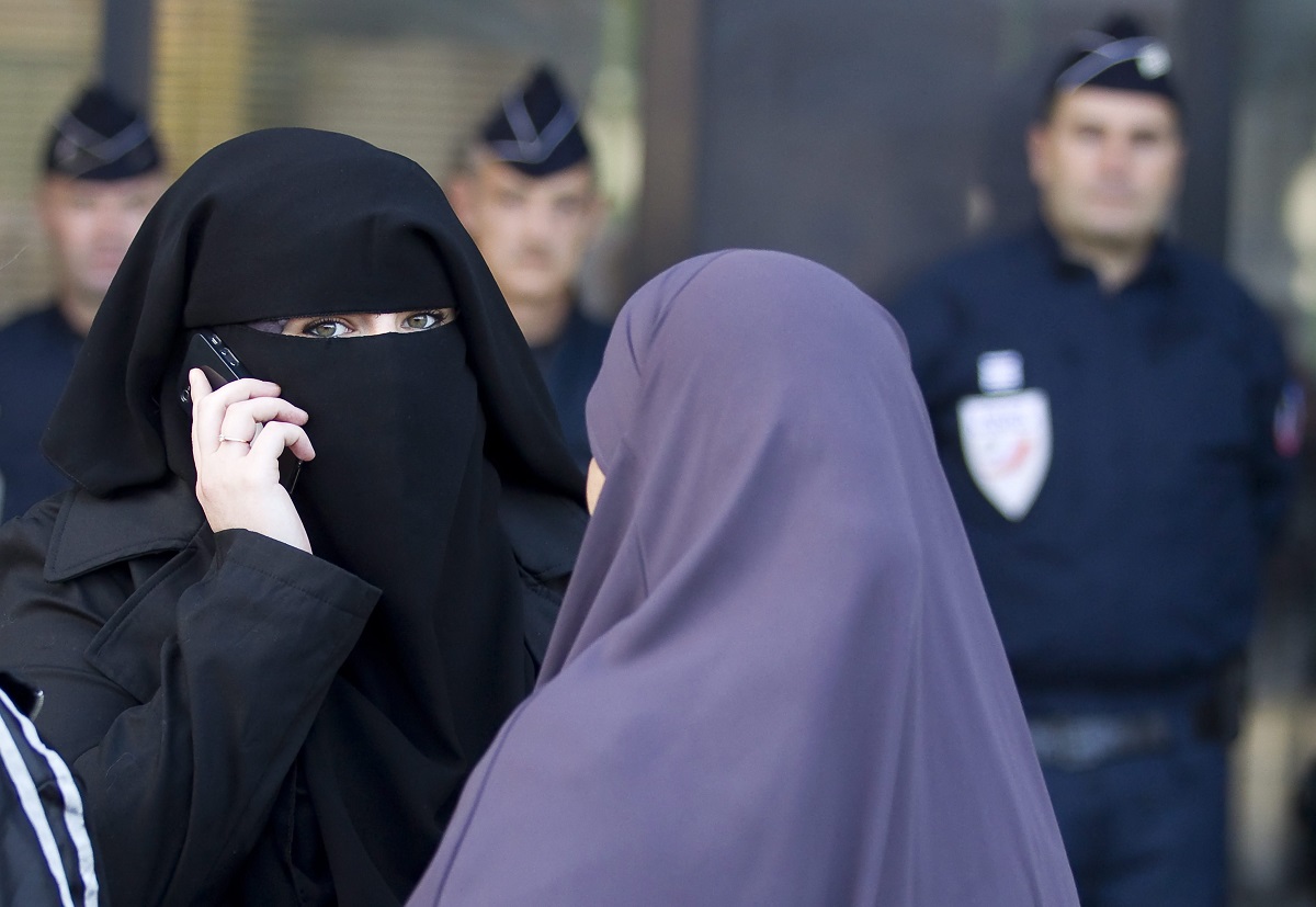 Una mujer vestida con niqab habla por teléfono a las puertas del tribunal de Meaux