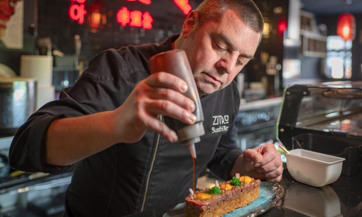 Rubén Ortiz termina un original steak tartar en la barra de su restaurante asiático ‘Zitro’, en Tomelloso. (Ciudad Real, Castilla-La Mancha). Foto: Sofía Moro