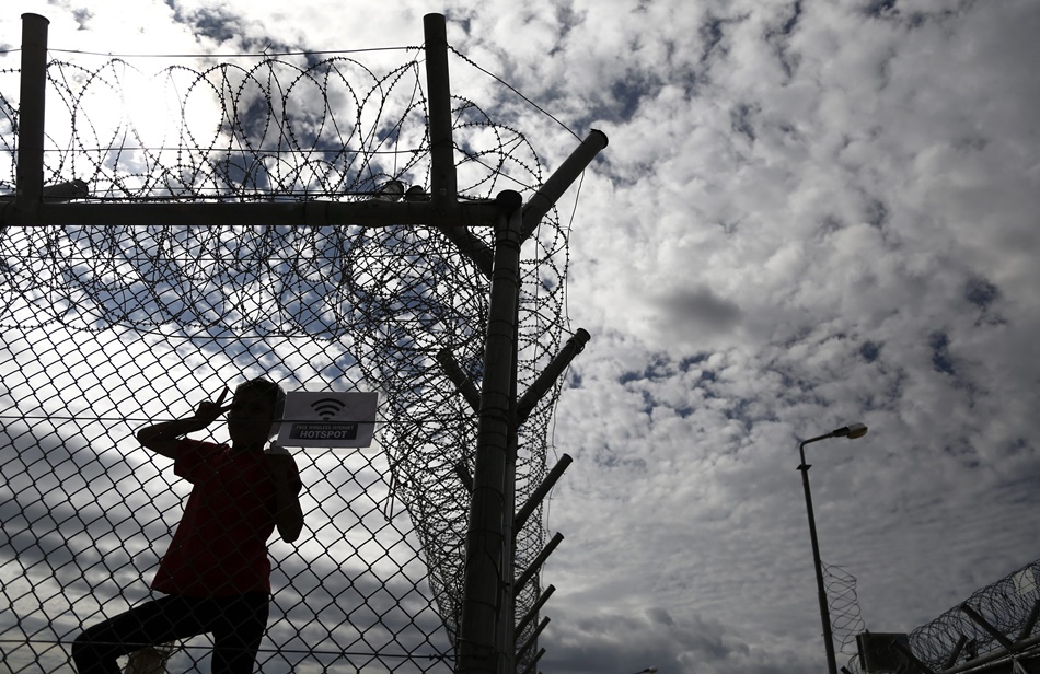Un niño iraquí en una valla en el centro de detención de inmigrantes de Amygdaleza, en Atenas (Grecia).