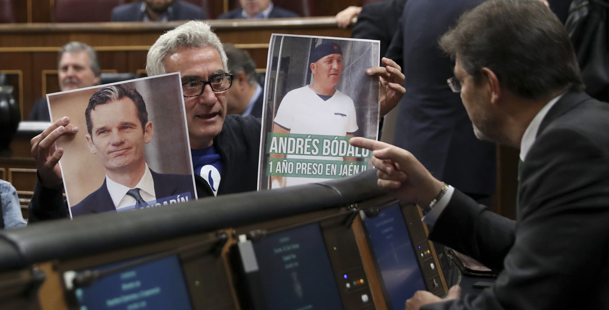 Diego Cañamero muestra dos carteles al ministro de Justicia para criticar la desigualdad entre Bódalo y Urdangarin.