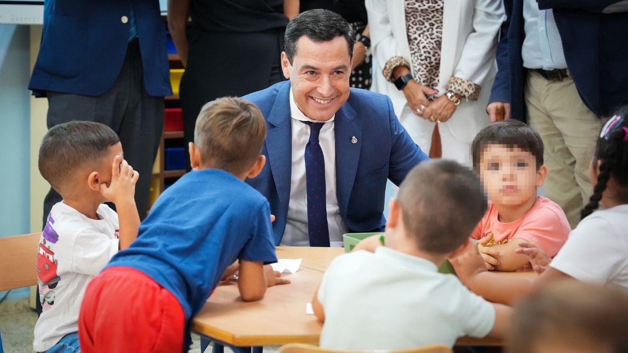 El presidente de la Junta de Andalucía, Moreno Bonilla, habla con alumnos durante la visita a un colegio / Archivo EP
