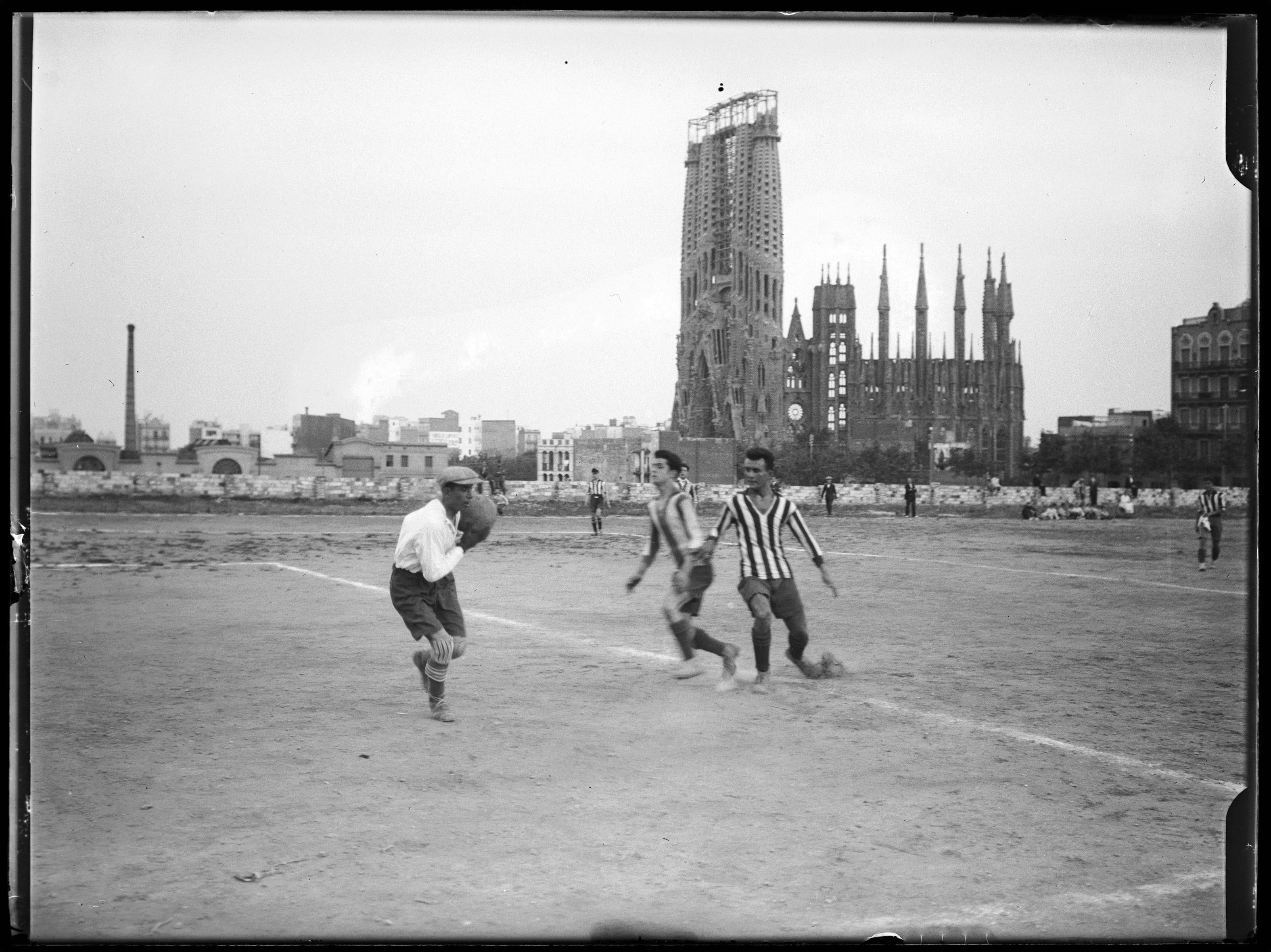 Imagen de un partido de fútbol entre el FC Barcelona y el RCD Europa en el año 1917 con la Sagrada Familia de fondo